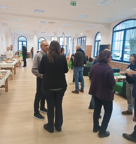 Una foto con partecipanti che stanno discutendo in piedi